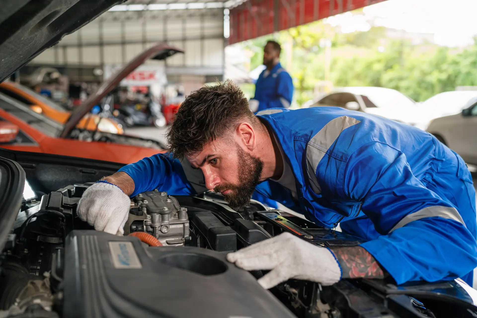 Auto mechanic in blue uniform are repair and maintenance auto engine is problems.